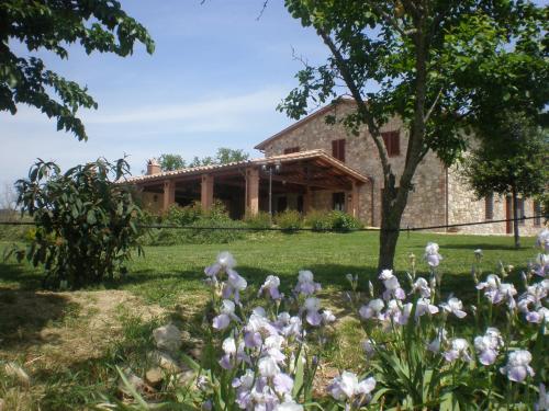 een tuin met witte bloemen voor een gebouw bij La Campagna Di Assignano in Collazzone