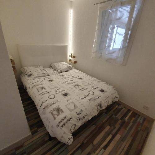 une chambre avec un lit avec une couette blanche dans l'établissement apt cosy, 4 pers, plein centre ville, parking offert, à Font-Romeu-Odeillo-Via