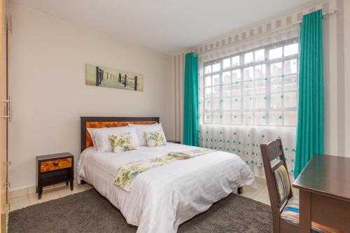 una camera da letto con un letto con tende verdi e una finestra di Fully furnished 1-bedroom Apartment in Eldoret a Eldoret