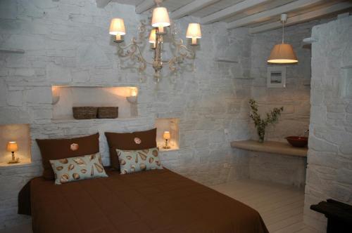 a bedroom with a bed and a chandelier at Chez Semiramis Aegean Pearl House for 8 persons 5'min from the beach in Serifos Chora