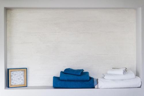 una mensola con asciugamani blu e bianchi in una stanza di B&B Al Chicco d'Uva a Morro dʼAlba