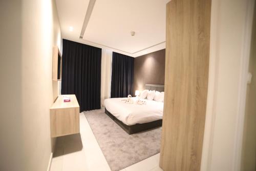 1 dormitorio con 1 cama y 1 habitación con espejo en فندق صحارى الخليج Sahara Gulf Hotel Apartments en Amán