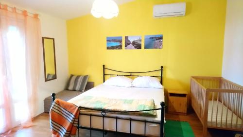 a bedroom with a bed and a yellow wall at Pirovac - most beautiful beaches in Dalmatia in Pirovac