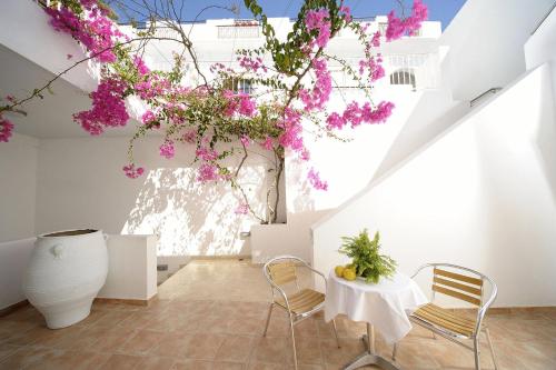 een kamer met een tafel, stoelen en bloemen bij Glaros Hotel Apartment in Agia Galini