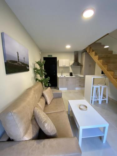 a living room with a couch and a table and a kitchen at Pousadas Mariñeiras,sl - AT "Camiño da Barca" in Muxia