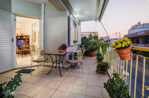 a patio with a table and chairs on a balcony at Marys house in Markopoulo