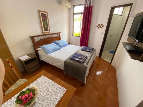 1 dormitorio con cama, mesa y TV en Hotel Ibajé en Bagé