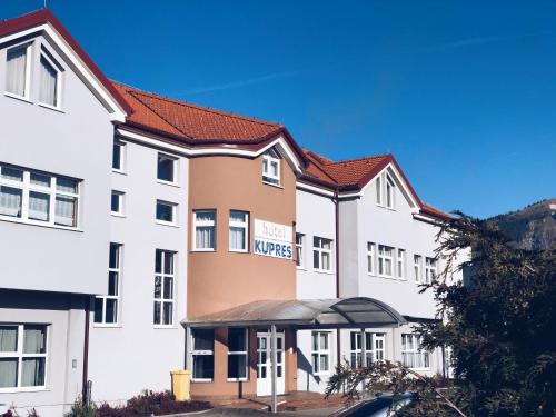 a row of white buildings with red roofs at Hotel Kupres in Kupres