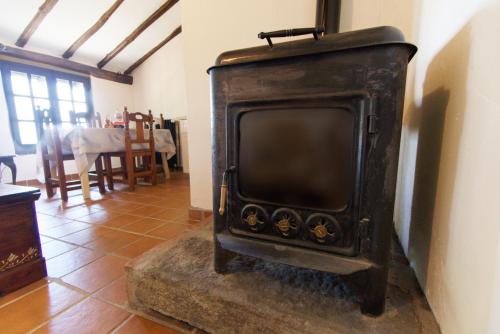 an old black stove in a room with a table at Casas Arbillas in Arenas de San Pedro