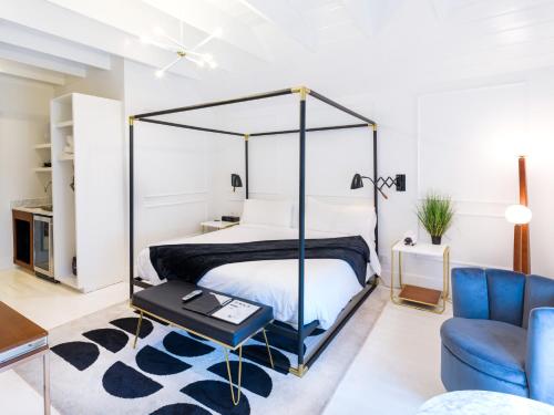 a bedroom with a canopy bed and a blue chair at American Beech Hotel in Greenport