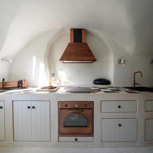 a kitchen with a stove and an oven in it at Potamos Luxury House, Private Pool, Santorini in Éxo Goniá