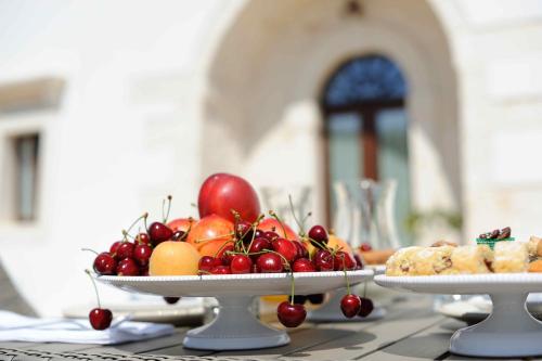 a table topped with two plates of fruit and pastries at Agriturismo Arco di Sole in Alberobello