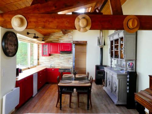 a kitchen with red cabinets and a table in it at - Le Patio - Calme, Chaleureux, Unique in Besançon
