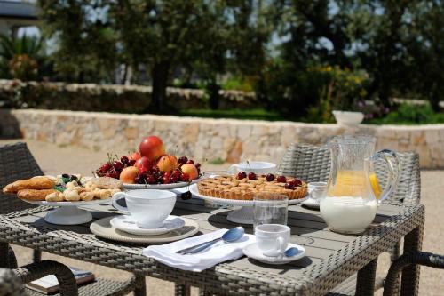 a table with plates of food and fruit on it at Agriturismo Arco di Sole in Alberobello