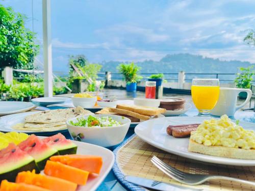 una mesa cubierta con platos de comida y bebida en Blinkbonnie Inn, en Kandy