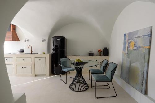 Éxo GoniáにあるPotamos Luxury House, Private Pool, Santoriniのキッチン(テーブル、椅子、冷蔵庫付)