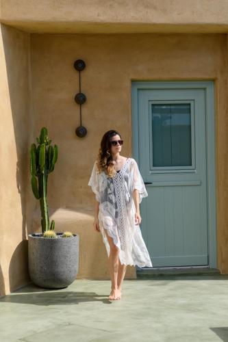 a woman standing in front of a building with a cactus at Potamos Luxury House, Private Pool, Santorini in Éxo Goniá