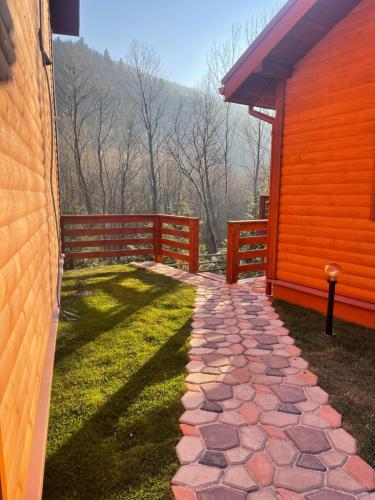a stone walkway next to a house with a fence at Villa Затишна de luxe in Mykulychyn