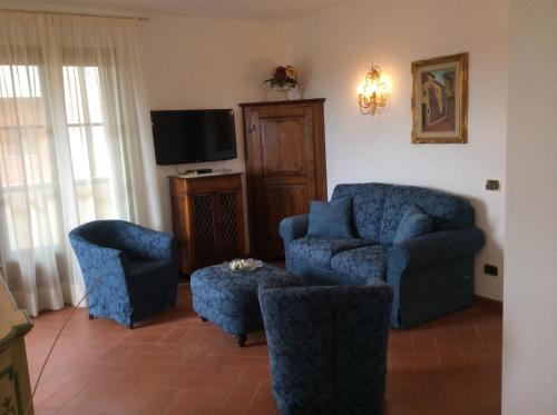 a living room with blue chairs and a tv at Il Porticato in Pisa