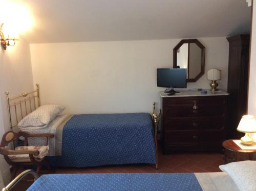 a bedroom with a bed and a dresser with a tv at Il Porticato in Pisa