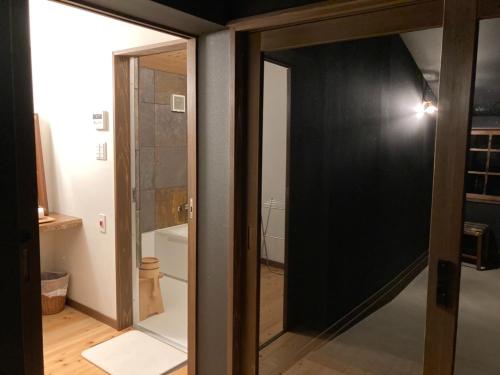 baño con una puerta de cristal que conduce a un aseo en villa YUUNOBI - Vacation STAY 78559v en Taragi