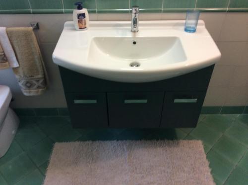 a bathroom with a white sink and a rug at Il Porticato in Pisa