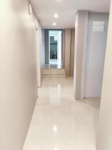 an empty hallway with white walls and white tile floors at Sunny Acres Villa, St.Lucia in Choc
