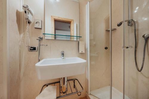 a bathroom with a sink, toilet and bathtub at Hotel Olimpia in Cortina dʼAmpezzo
