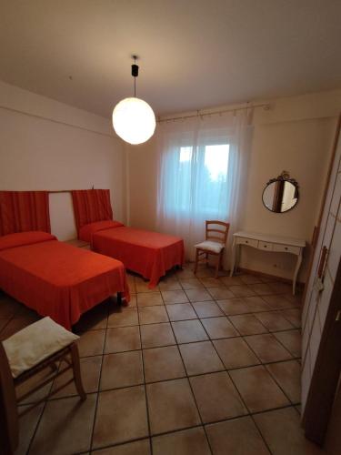 Habitación con 2 camas, silla y espejo. en Bougainvillea, en Marina di Modica