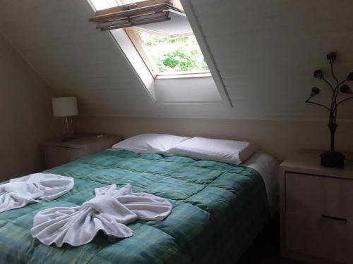 1 dormitorio con 1 cama con toallas en Casa Planalto, en Gramado