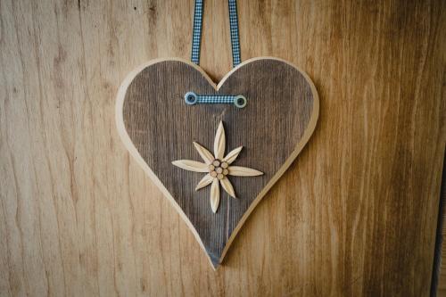 a wooden heart with a flower on a wooden wall at Panorama-Ferienhaus im Stubaital in Mieders