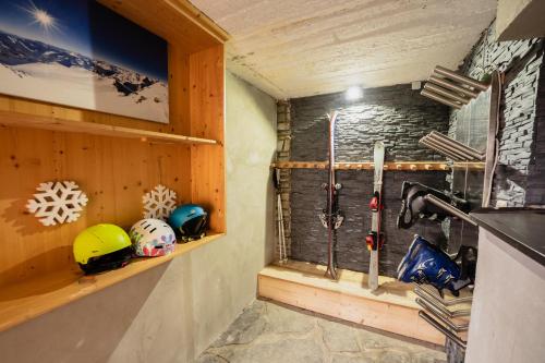 um quarto com capacetes e equipamento de esqui numa parede em Panorama-Ferienhaus im Stubaital em Mieders