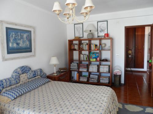 Un dormitorio con una cama y una estantería. en Golf, Praia, Piscina, Ar Puro, en Amoreira