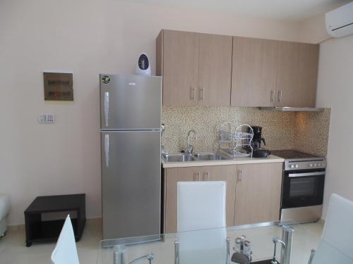 a kitchen with a stainless steel refrigerator and a sink at Palaiologou Panorama Apartments in Mantamádos