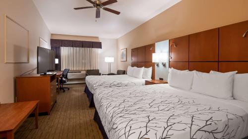 A bed or beds in a room at Best Western Plus Silver Saddle Inn
