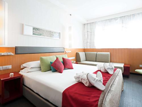 um quarto de hotel com duas camas com toalhas em Novotel Roma Eur em Roma
