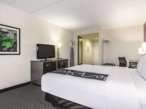 a hotel room with a bed and a flat screen tv at La Quinta by Wyndham Warwick Providence Airport in Warwick