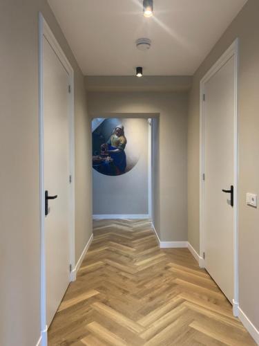 a hallway with wooden floors and a painting on the wall at 'T Hûske 66 in Burum