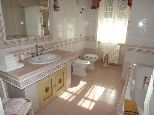 bagno con lavandino, servizi igienici e specchio di B&b La Balaustra ad Andrano