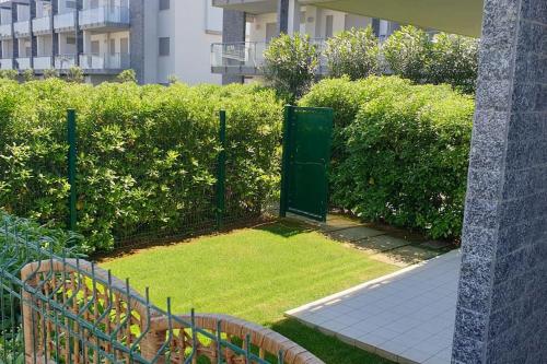 um jardim com uma porta verde na relva em Appartamento alle Dune! Dalla piscina alla spiaggia in 30 mt! em Silvi Marina