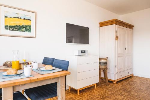 um quarto com uma mesa e um armário com comida em FEWO Fördeblick em Flensburg