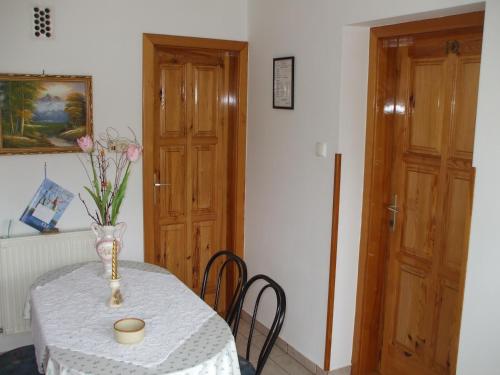 a table with a vase of flowers on it at Petrovics Apartmanház 1 in Bük