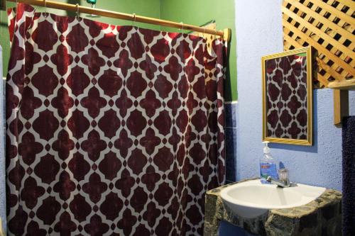 a bathroom with a black and white shower curtain and a sink at Eco-Hotel Mayachik in San Juan La Laguna