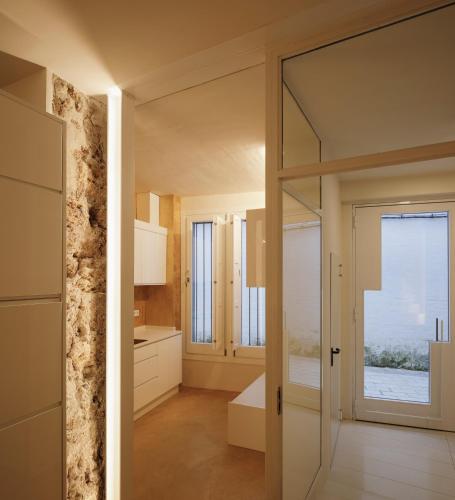 a bathroom with a glass door leading into a kitchen at Casa Rural Torrejón XV in Priego de Córdoba