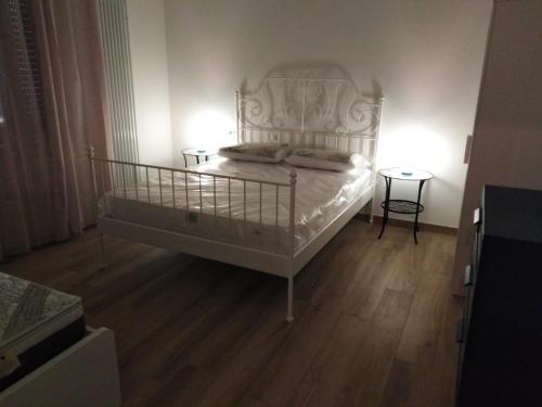 um quarto com uma cama branca e piso em madeira em FAMILY em Bolonha