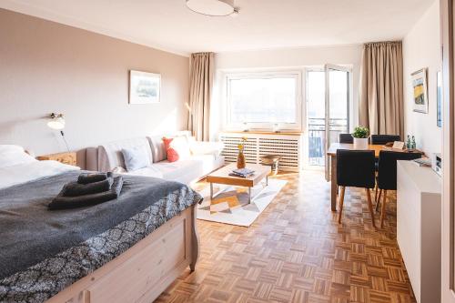 um quarto com uma cama e uma sala de estar com um sofá em FEWO Fördeblick em Flensburg