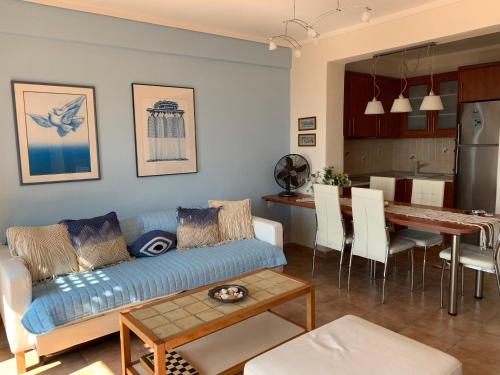 a living room and kitchen with a couch and a table at Yulia Guest House in Ouranoupoli