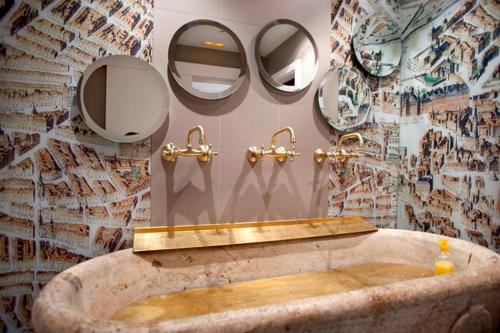 W łazience znajduje się duża kamienna wanna i lustra. w obiekcie Posada del Dragón Boutique Hotel w Madrycie
