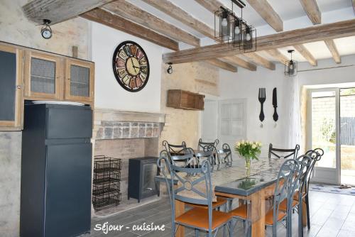 Il comprend une cuisine et une salle à manger avec une table et une cheminée. dans l'établissement Gîte LE LOGIS De La CHARNIE Confort pour 14 personnes à Chemiré-En-Charnie, à Chemiré-en-Charnie