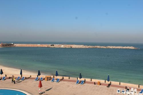 een strand met stoelen en parasols en de oceaan bij Golden Jewel Hotel in Alexandrië